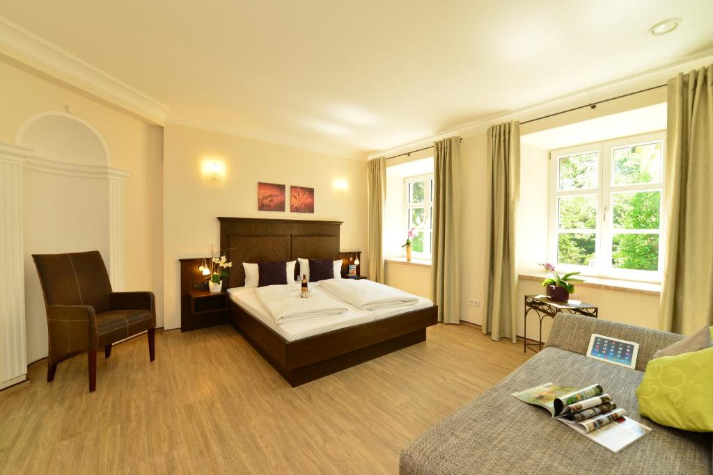 sypialnia z łóżkiem i kanapą w obiekcie Autenrieder Brauereigasthof w mieście Ichenhausen