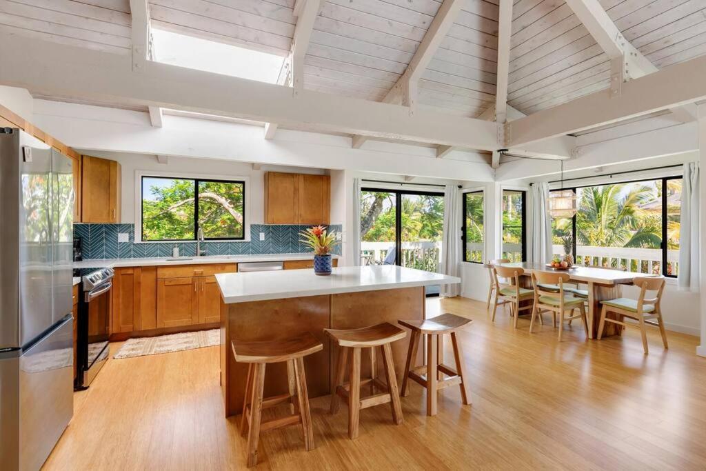 a kitchen with a island and chairs in a room at Newly listed luxury home - great location + views in Princeville