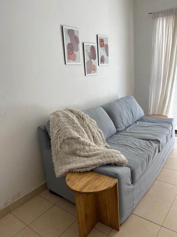 eine blaue Couch in einem Wohnzimmer mit einer Decke in der Unterkunft Baires Garden in Buenos Aires