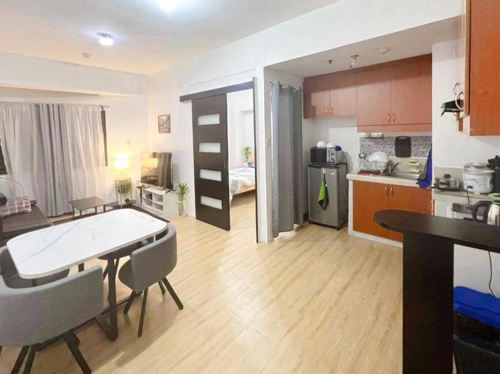 Il comprend une cuisine et un salon avec une table et des chaises. dans l'établissement One Bedroom condo Unit in Eastwood Libis . Fast free wifi /netflix, à Manille