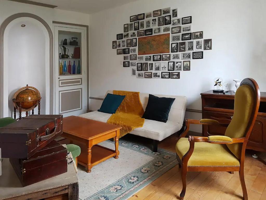 ロン・ル・ソーニエにあるMaison centre-ville calme avec jardinのソファとテーブルのあるリビングルーム
