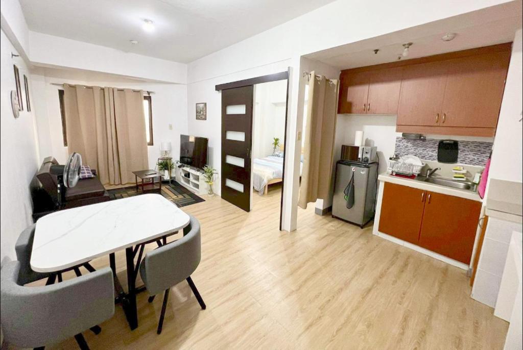 a kitchen and a living room with a table and chairs at One Bedroom Condo with fast wifi at Eastwood Lafayette tower Quezon city in Manila