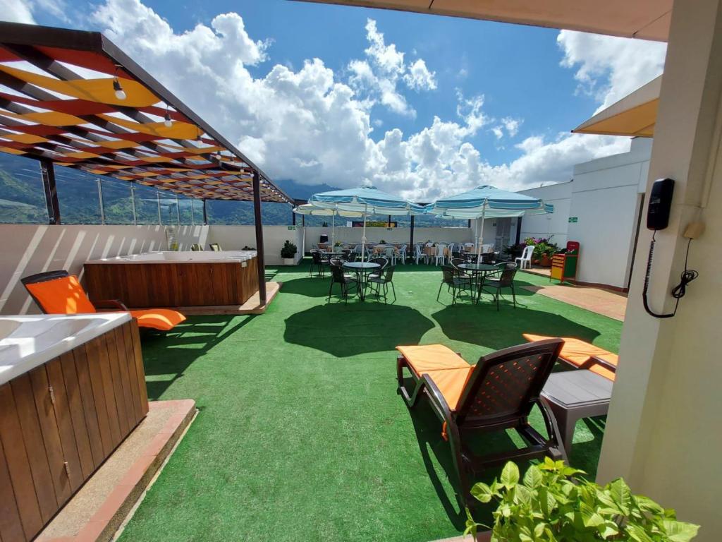 a patio with tables and chairs on a balcony at HOTEL VERANO in Ibagué