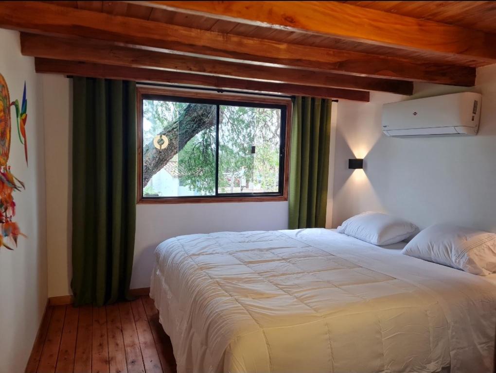a bedroom with a large bed and a window at Haasienda - Nido del Colibri - Casa de Arbol 