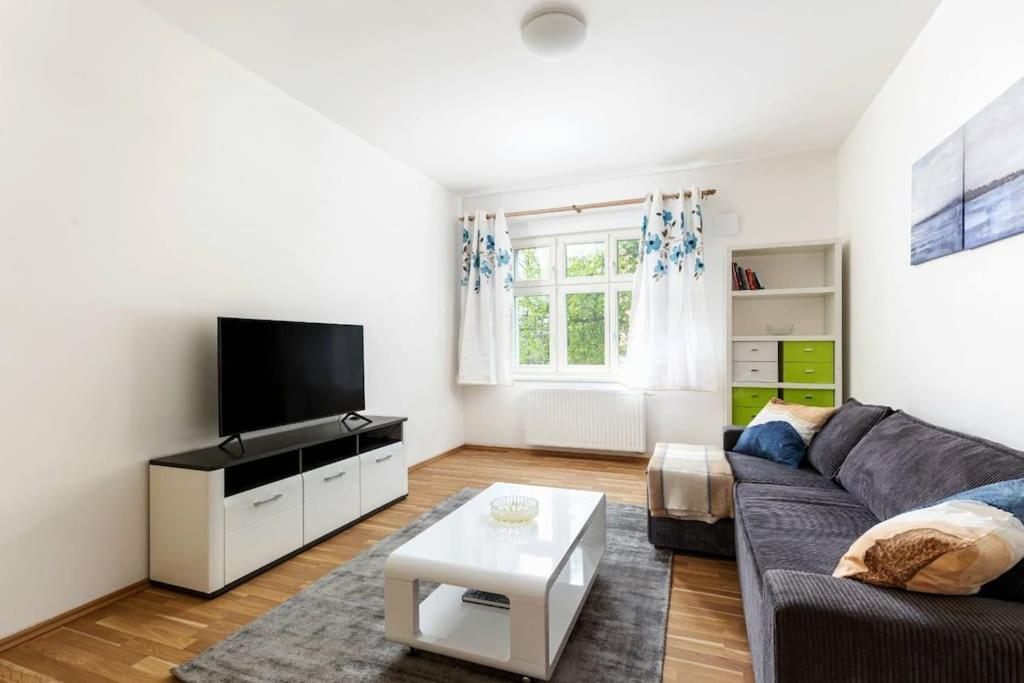 un soggiorno con divano e TV di Modern Apartment 6min from the Prague Castle a Praga