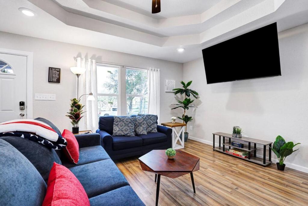 At Ease في سان انطونيو: غرفة معيشة مع أريكة زرقاء وتلفزيون بشاشة مسطحة