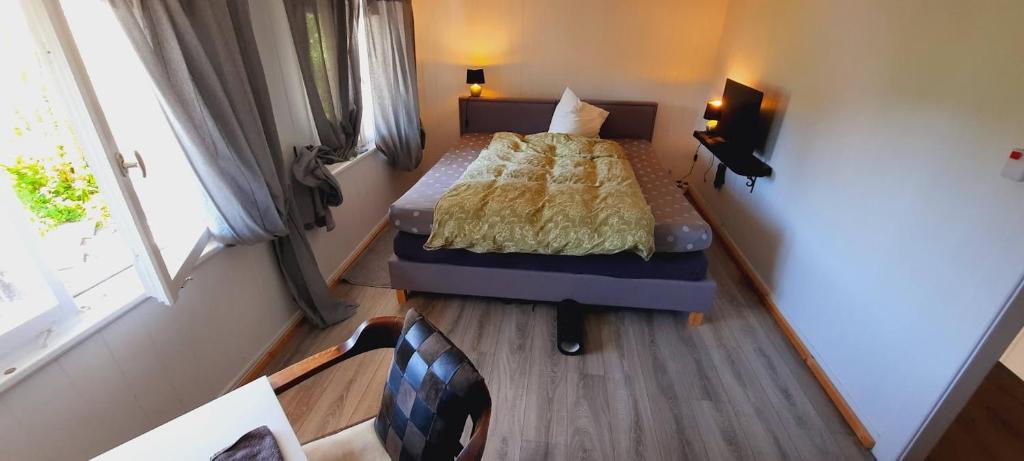 HEIMELIGE SCHWARZWALD STUBE nahe bei Freiburg في تودتناو: غرفة نوم صغيرة مع سرير وأريكة