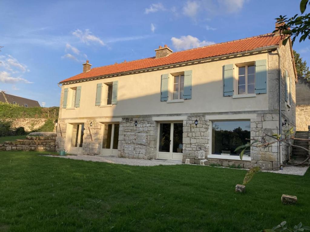 a large stone house with a green yard at Maison de village charmante avec jardin et terrasse, proche de Soissons, idéale familles et animaux acceptés - FR-1-532-19 in Buzancy