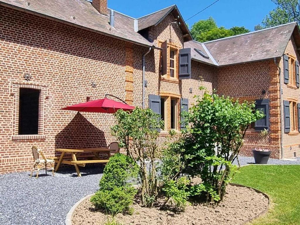 d'une terrasse avec une table et un parasol rouge. dans l'établissement Gîte Fontenelle, 4 pièces, 6 personnes - FR-1-532-20, 