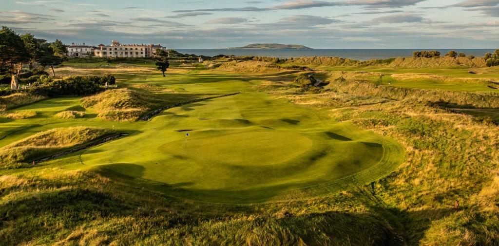 an aerial view of a golf course with the ocean in the background at Portmarnock Resort & Jameson Golf Links in Portmarnock