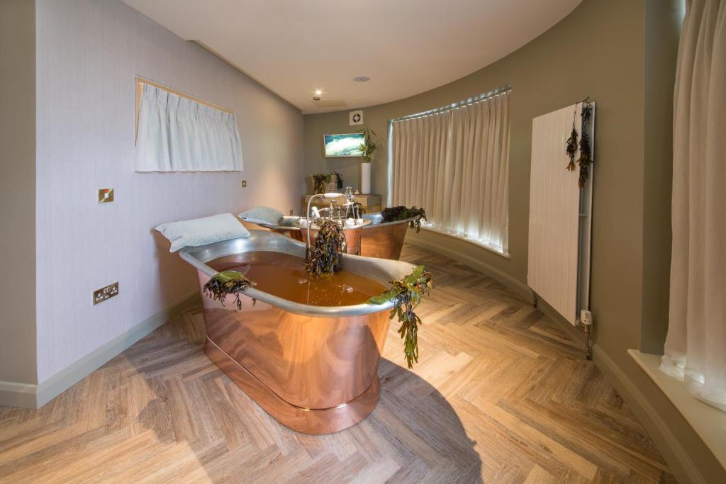 a bathroom with a tub in the middle of a room at Portmarnock Resort & Jameson Golf Links in Portmarnock