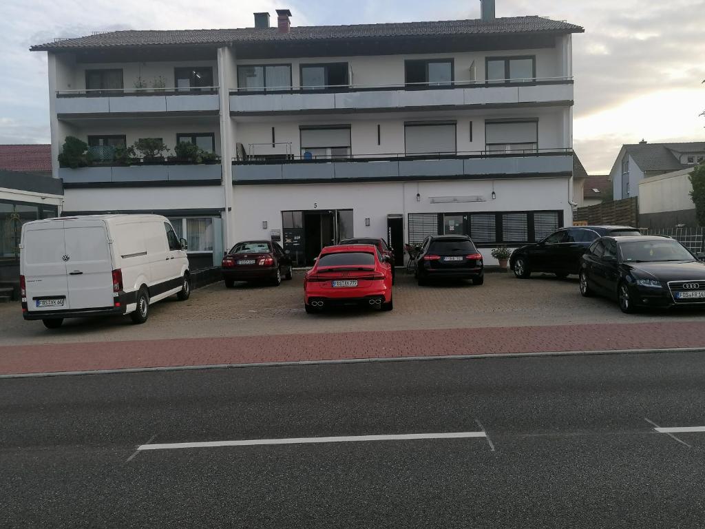 un gruppo di auto parcheggiate in un parcheggio di fronte a un edificio di Ferienwohnung Deti a Lossburg