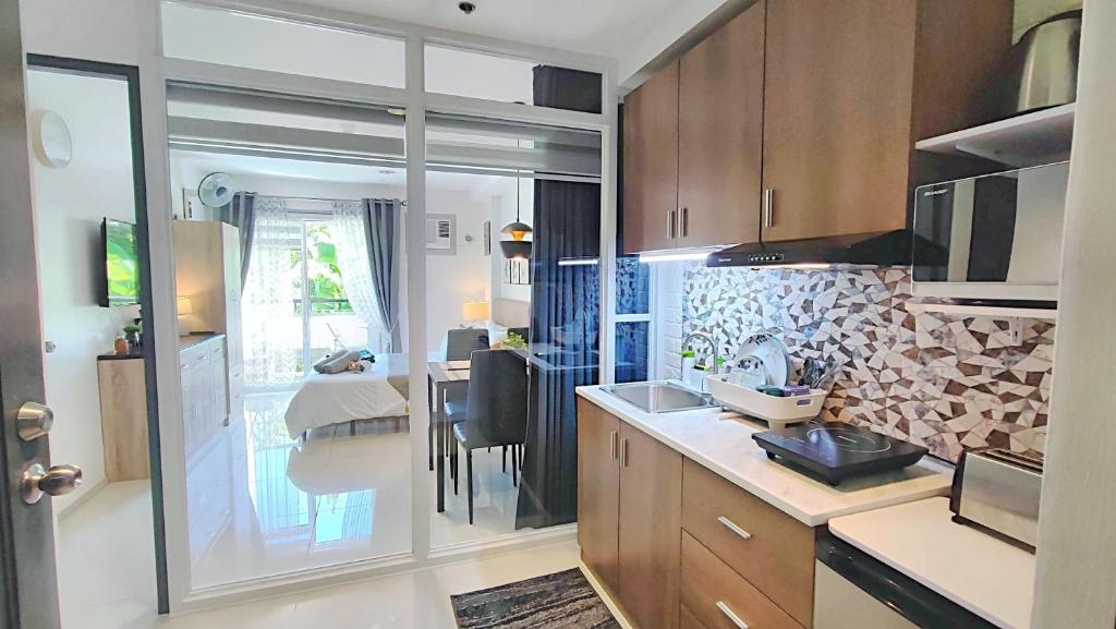 a kitchen with a counter and a dining room at CityCondo, 2nd Fl, 30 sqm, near CPU, balcony and parkview, Netflix, free parking in Iloilo City