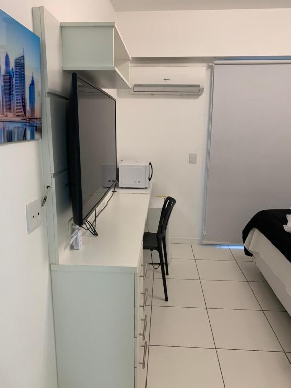 a room with a desk with a television and a bed at Rio Stay Suite B in Rio de Janeiro