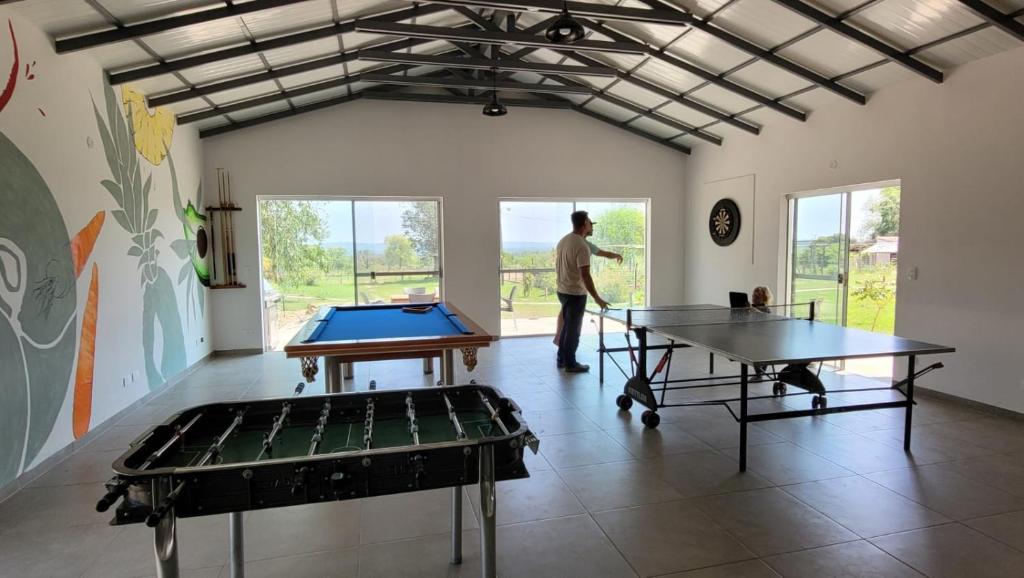Ein Mann steht in einem Raum mit zwei Tischtennisplatten in der Unterkunft Haasienda - Nido del Loro - Casa de Arbol 