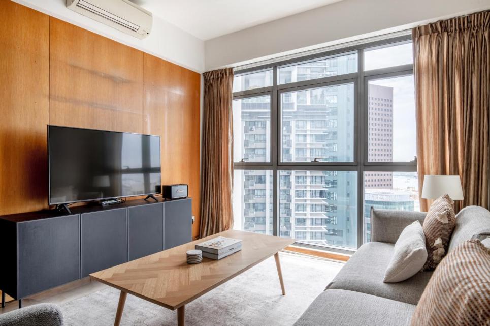 a living room with a couch and a tv at Sunny 1BR / 1Bath apartment in Singapore! in Singapore