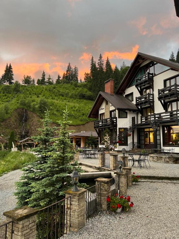 a house with a christmas tree in front of it at Pensiunea Poiana Izvoarelor in Vatra Dornei