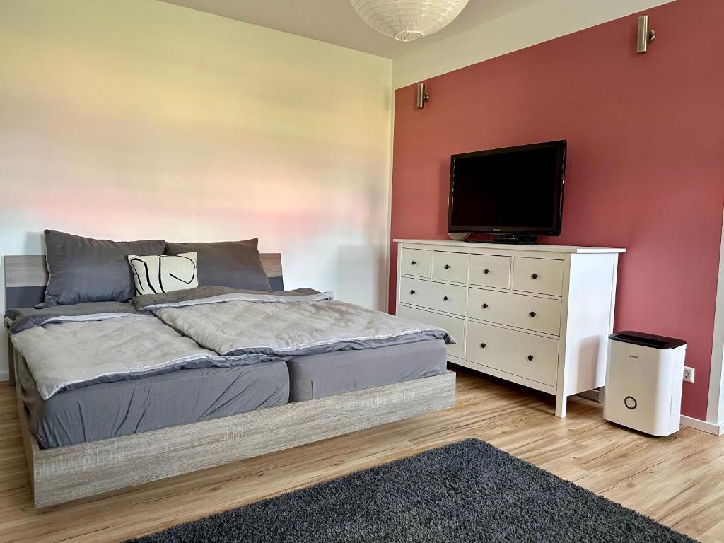 a bedroom with a bed and a flat screen tv at Ferienwohnung Storchennest in Eisfeld