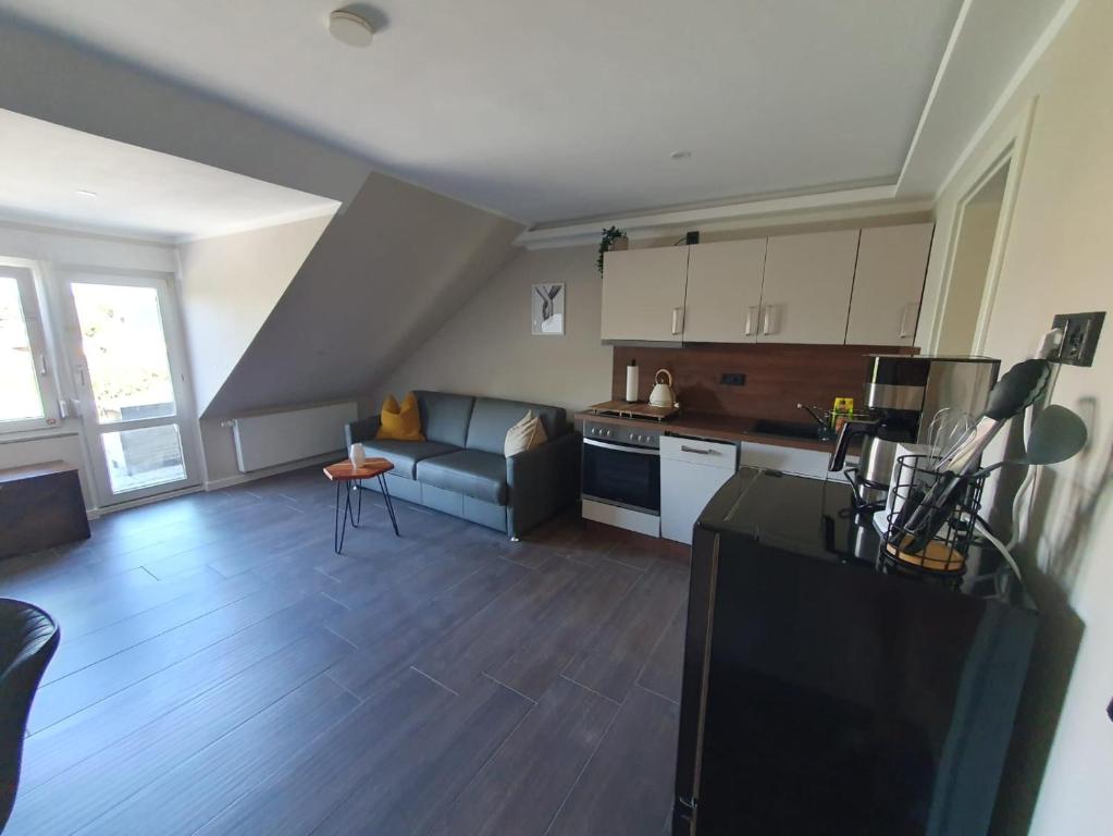 a living room with a couch and a kitchen at Neumühler Hof- Ferienwohnung "Benjamin" mit großer Privater Dachterasse und guter Anbindung in die City in Schwerin