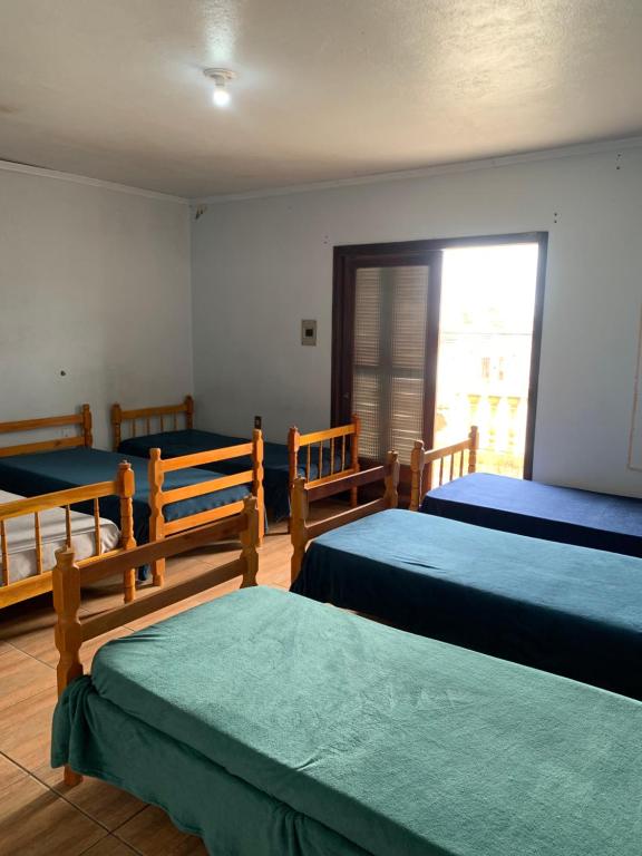 Hostel 858 في بيلوتاس: غرفة نوم بثلاث اسرة ونافذة