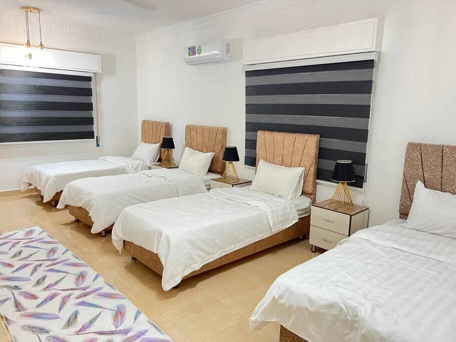 um quarto com três camas num quarto em Lovely 3 bedrooms rental unit em Aqaba