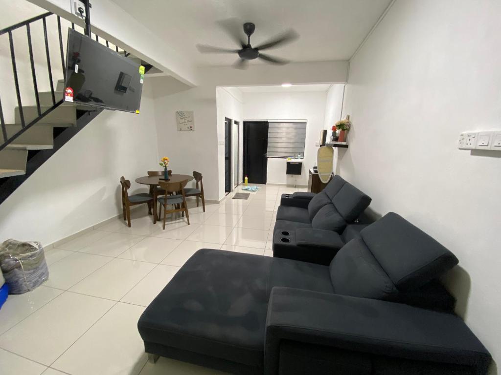 a living room with a couch and a ceiling fan at Pagoh Town Homestay in Pagoh