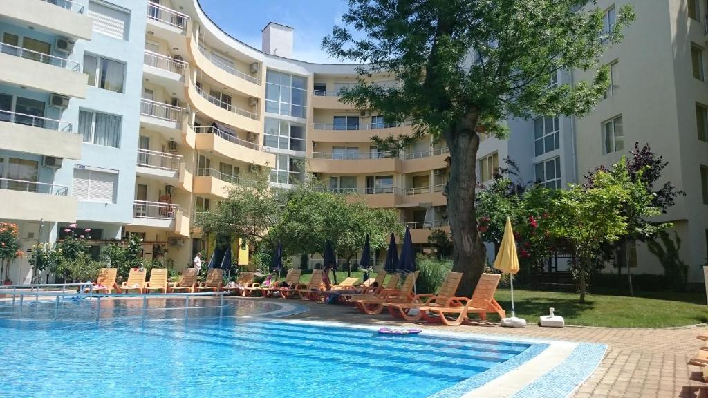 a swimming pool in front of a large apartment building at Yassen Holiday Village in Sunny Beach