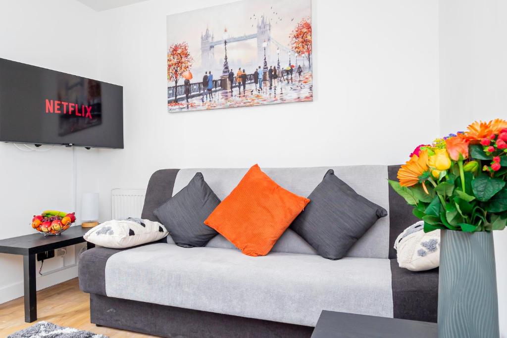 a living room with a gray couch with orange pillows at 8 Beds, 3baths Perfect For Contractors & Teams in Basingstoke