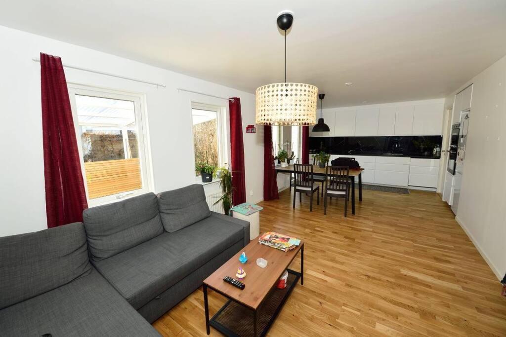 uma sala de estar com um sofá e uma mesa em Radhus med bekvämt läge em Täby