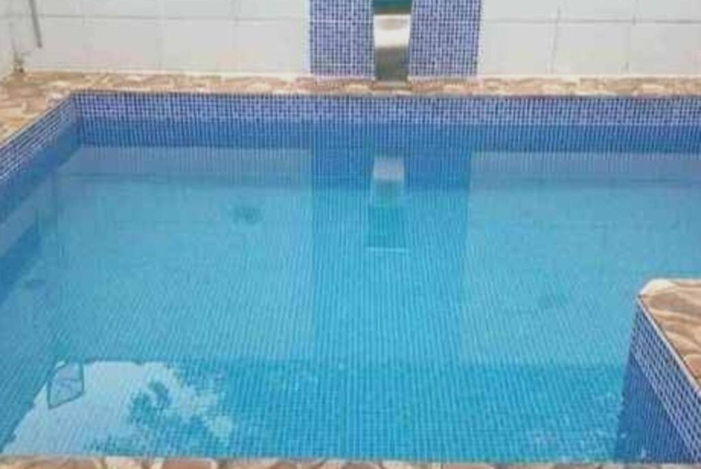 una gran piscina de agua azul en Casa de Praia com Piscina em Mongagua - Disponivel Carnaval en Mongaguá
