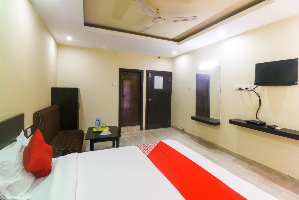 Habitación de hotel con cama y TV de pantalla plana. en A1 ROOMS SEA GOLD ( COTTAGE) PURI BEACH en Puri