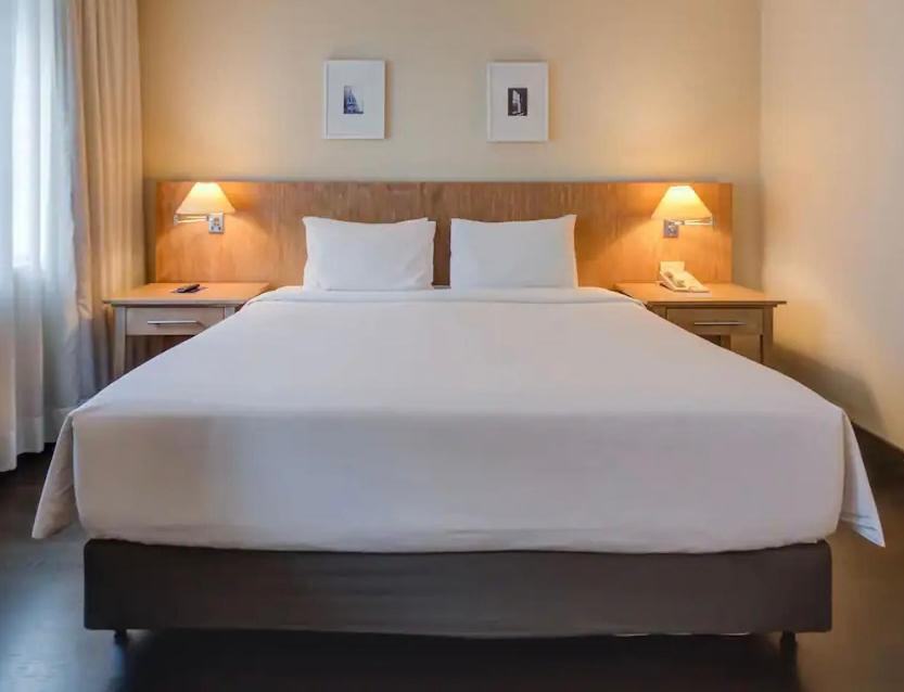 Suite executiva reformada dentro do hotel Radisson في ساو باولو: سرير أبيض كبير في غرفة الفندق