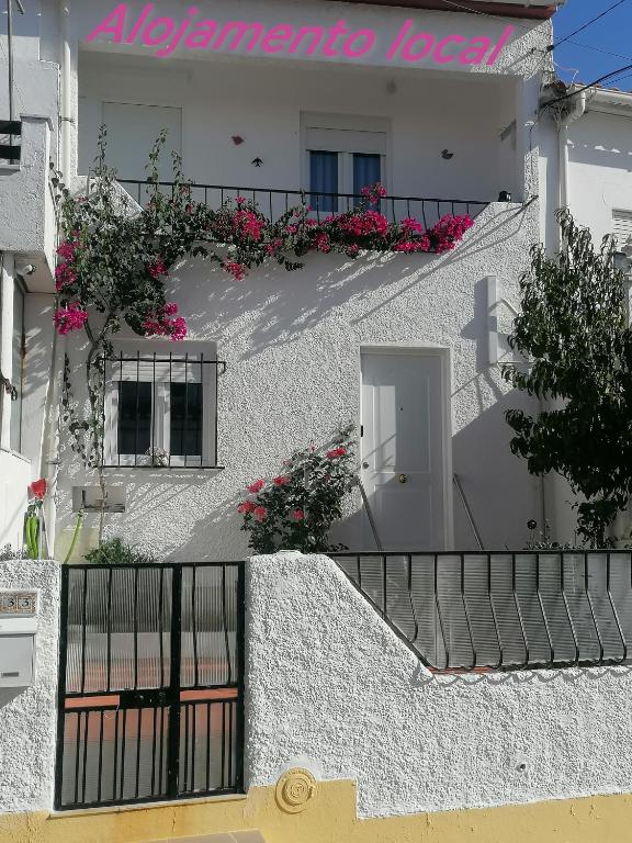 a white building with flowers on a balcony at Cantinho da Familia in Avis