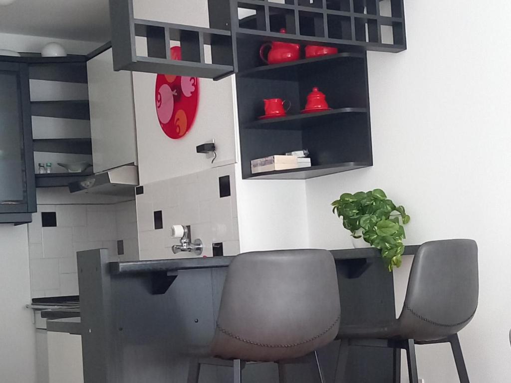 a kitchen with two chairs and a table with a plant at Apartman MINNA2, free parking in Osijek
