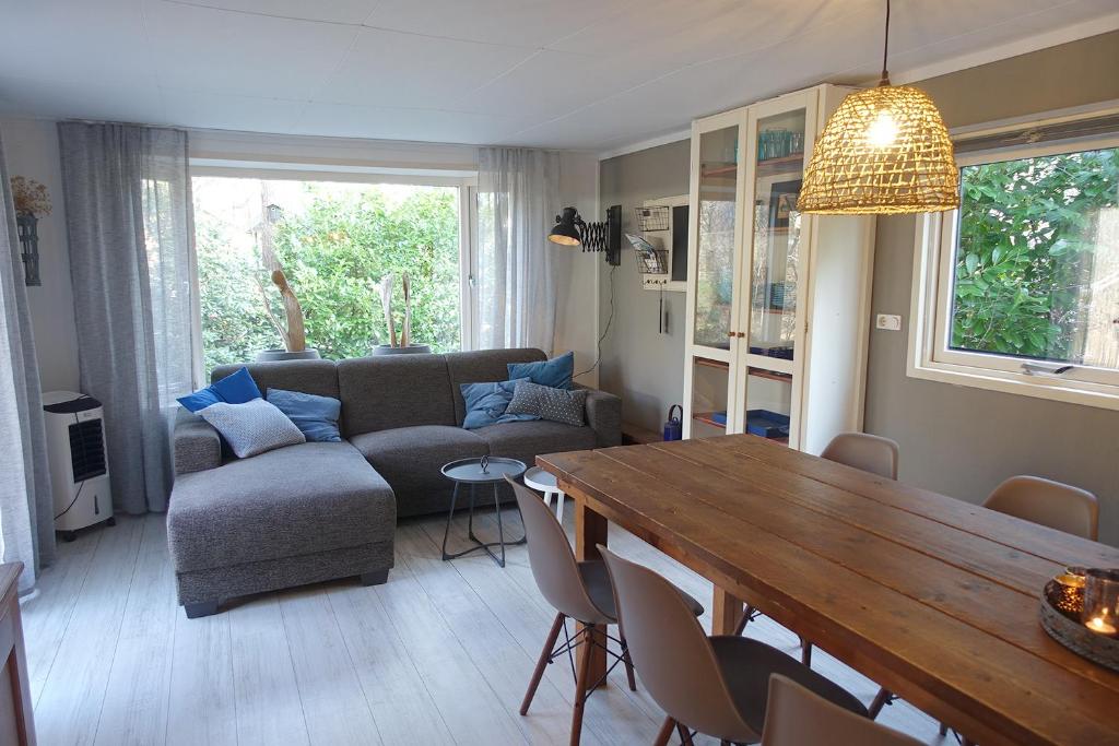 un soggiorno con tavolo e divano di Vechtdalchalet De Eekhoorn, 5 sterren vakantiepark Raalte a Raalte