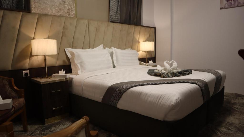 ein Hotelzimmer mit einem großen Bett mit zwei Lampen in der Unterkunft Odst Al Madinah Hotel in Medina
