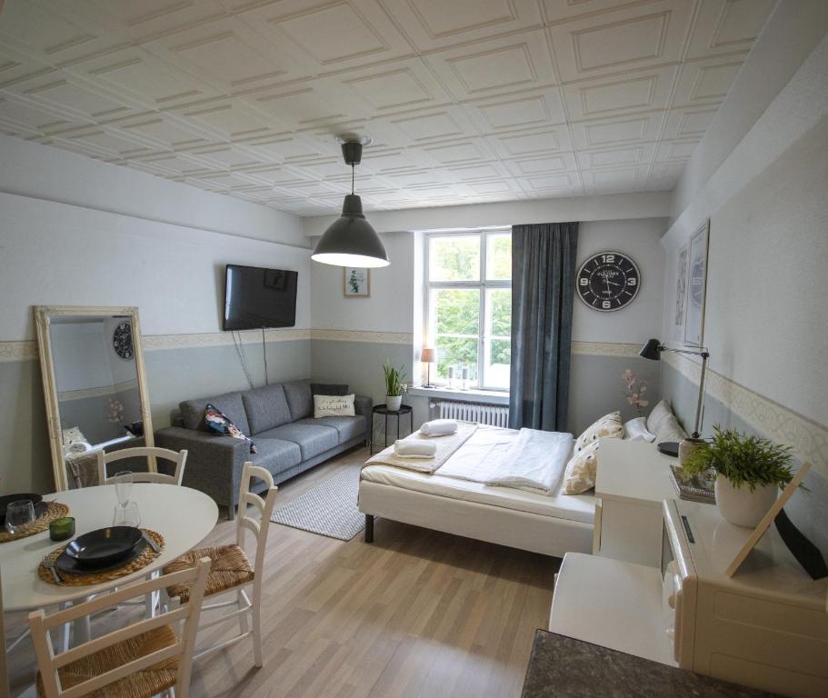 een woonkamer met een bank en een tafel bij Atmospheric hundred-year-old stone house apartment near Aurajoki in Turku