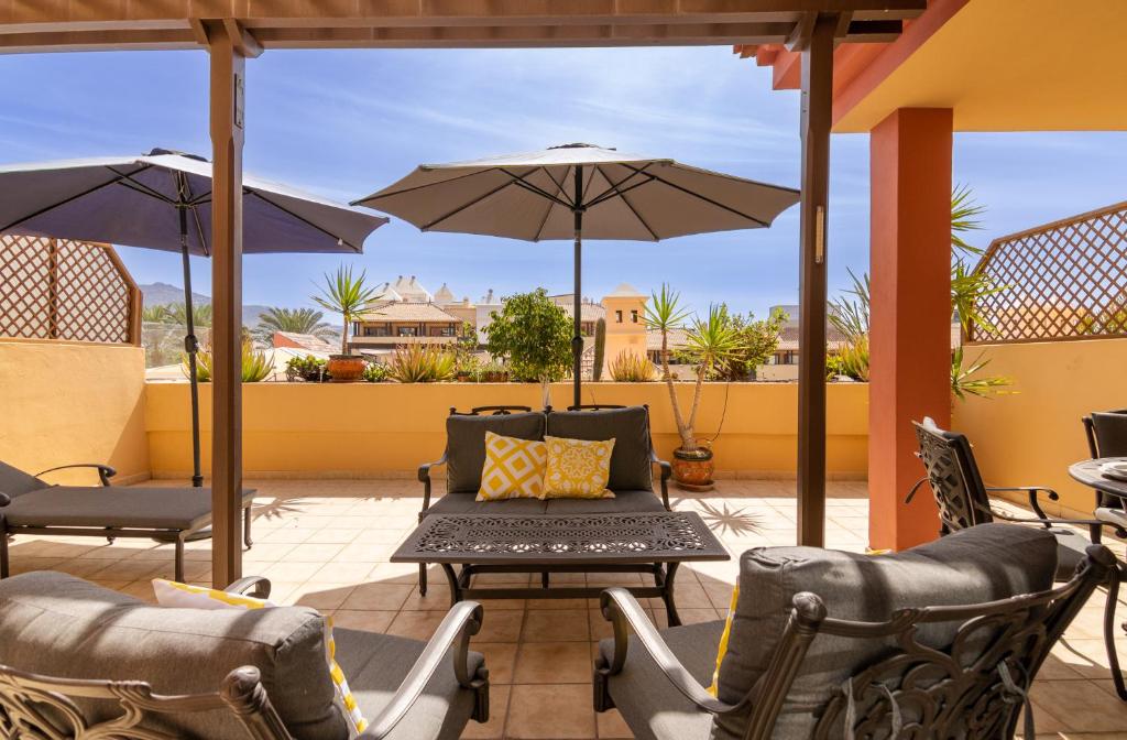 a patio with chairs and tables and umbrellas at Terrazas del Duque II Hideaway in Adeje