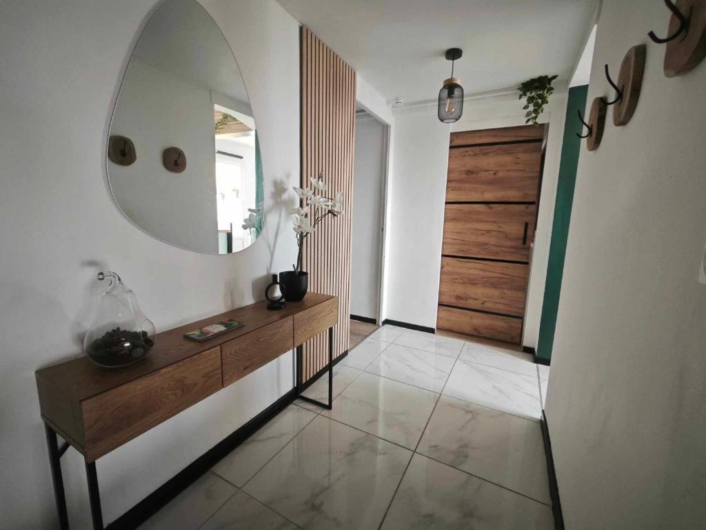 La salle de bains est pourvue d'un miroir, d'une commode en bois et d'une porte. dans l'établissement Appart proche plage Calais, à Calais