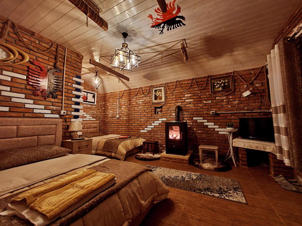 a bedroom with a bed and a brick wall at Vilat Pllumaj in Gropat e Selcës