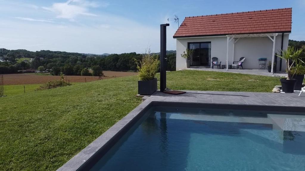 a house with a swimming pool in the grass at Gîte entre mer et montagne in Laa-Mondrans