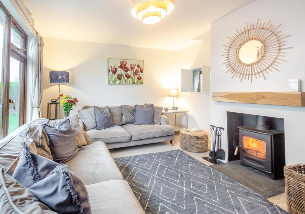 a living room with a couch and a fireplace at Bryn Penmaen in Pwllheli