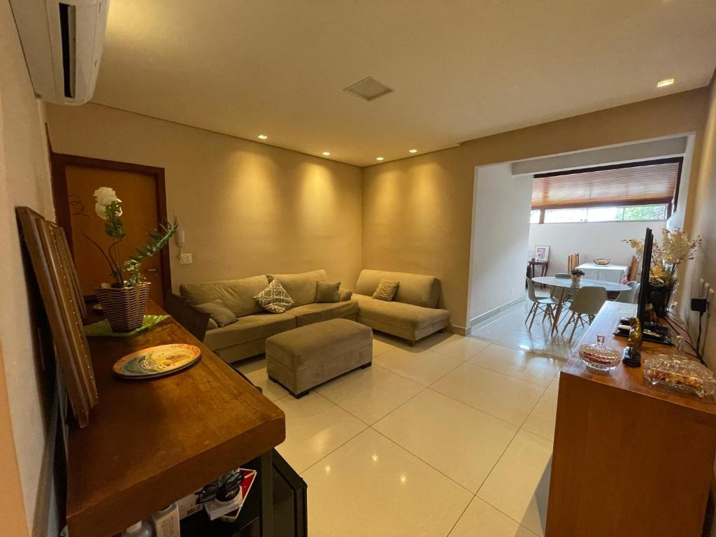 uma sala de estar com um sofá e uma mesa em Apê na Pampulha 3Q, Ar Split, Churrasco e 2 Vagas em Belo Horizonte
