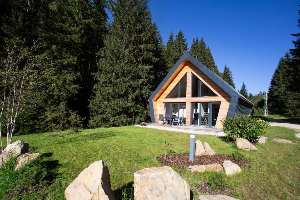 a small cabin in the middle of a grassy field at Chalet Belveder Železná Ruda in Železná Ruda