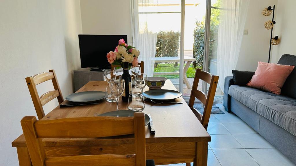 - une table à manger avec des chaises et une table fleurie dans l'établissement Superbe appartement En baie de Somme, à Cayeux-sur-Mer