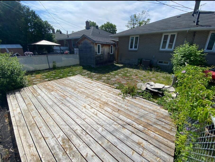 un patio con terraza de madera frente a una casa en 3 Bedroom Near downtown Ottawa en Ottawa