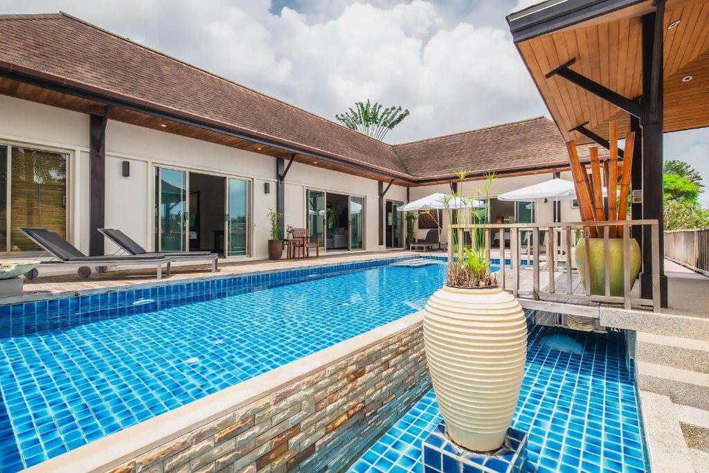 a swimming pool with a vase next to a house at Ivory Pool Villa in Nai Harn in Rawai Beach