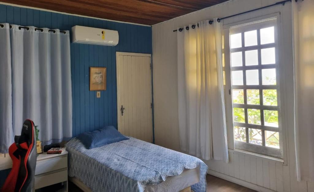 Schlafzimmer mit einem Bett und einem Fenster in der Unterkunft Casa lindo aconchego praia mar in Itaparica Town
