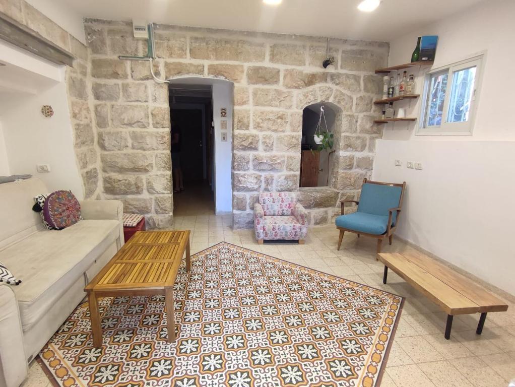 een woonkamer met een bank en een tafel en stoelen bij גינה ירושלמית in Jeruzalem