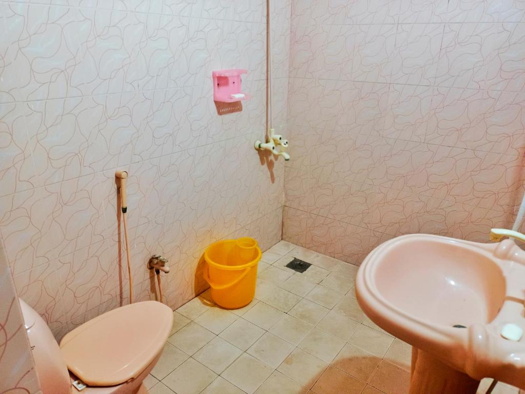 a small bathroom with a sink and a toilet at Jinnah inn Guest House in Karachi